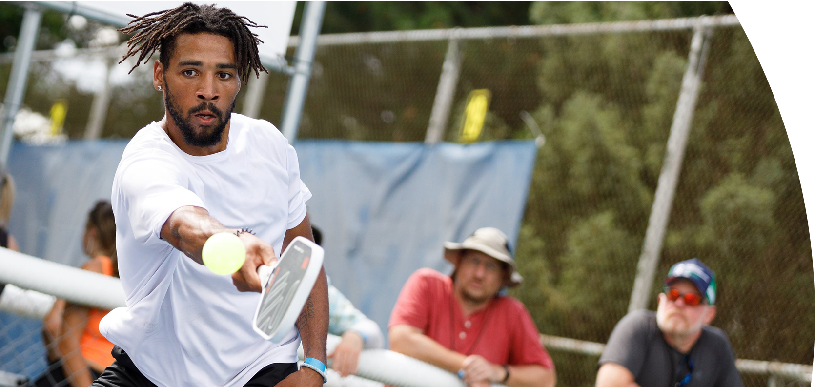 Person playing pickleball with a Revolin paddle with others in the background