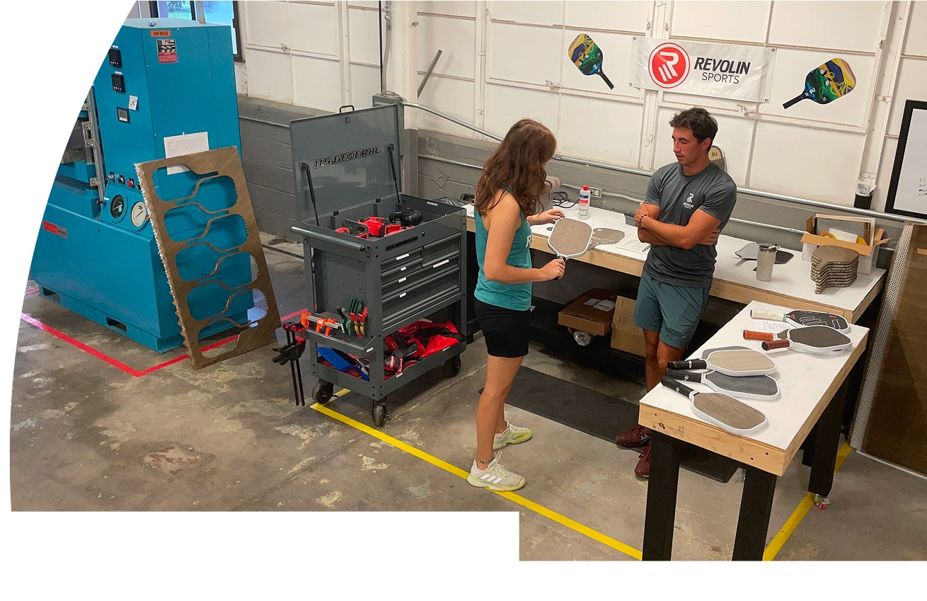 Two people working in a Revolin workshop with tools and equipment.